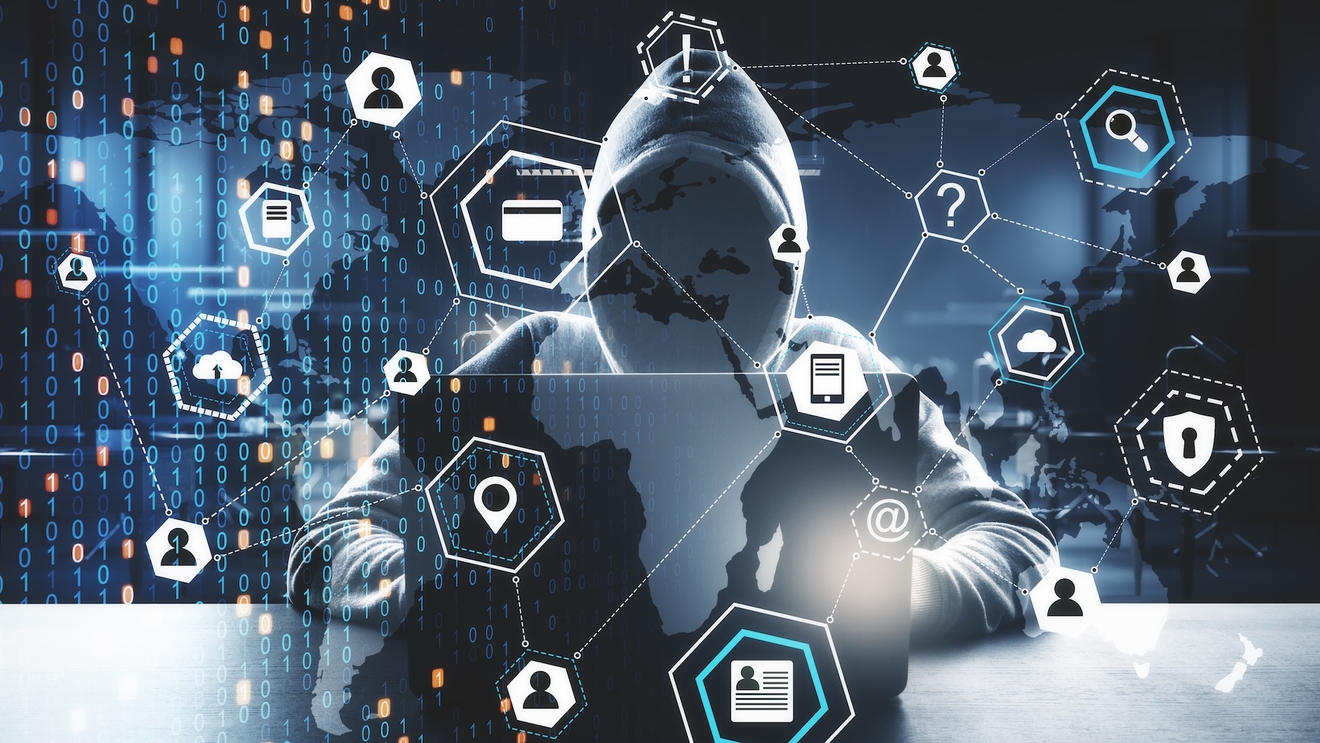 A hacker working on a laptop with graphics floating above them